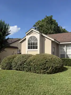Residential exterior with an arched half-round specialty window above rectangular windows on a gable, from a Shore Tint & More glazing job